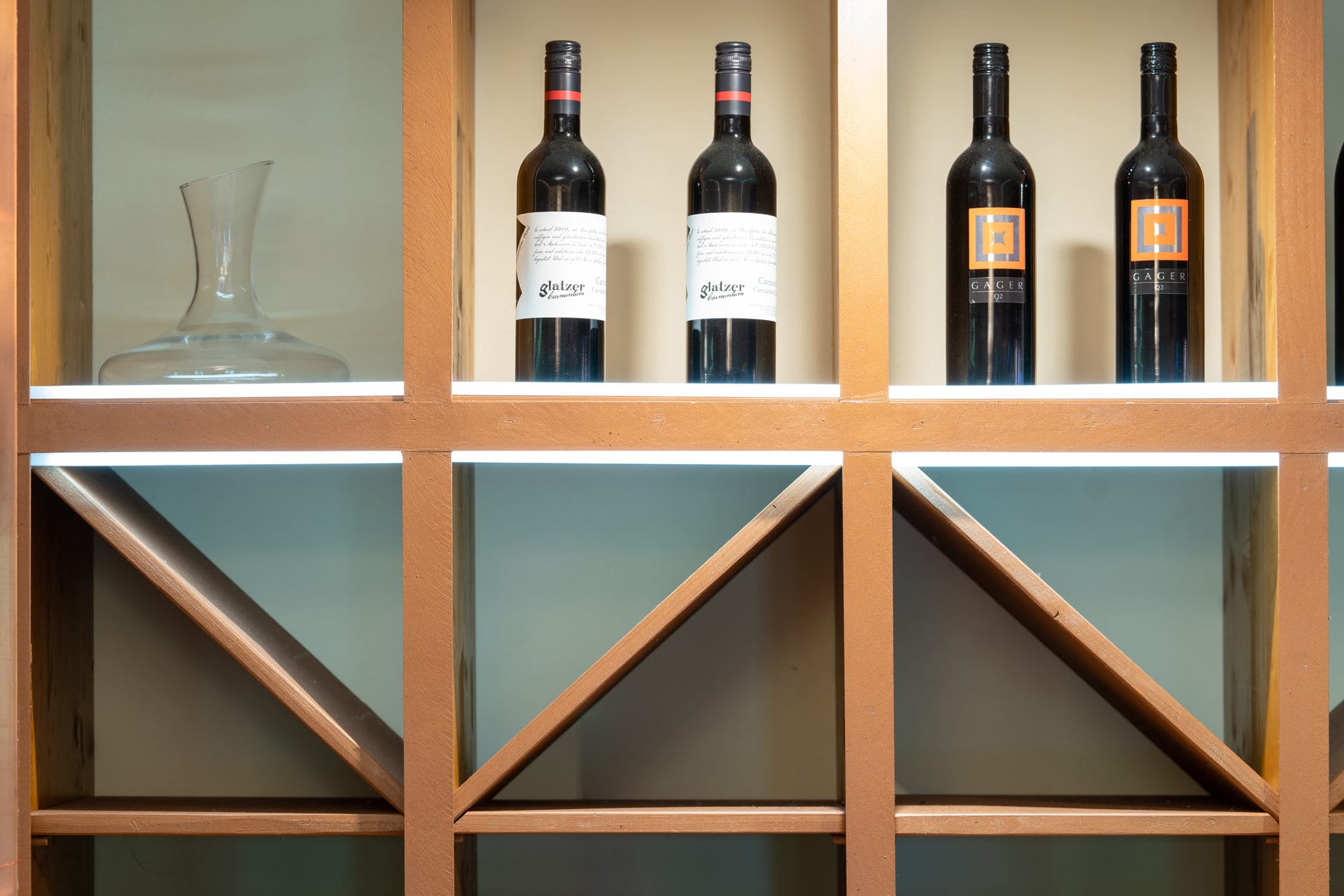 20220908_9280 Regal mit Weinflaschen und Dekanter, Teil des gemütlichen Ambientes im Restaurant Das Chadim, ideal für Veranstaltungen und Feiern.