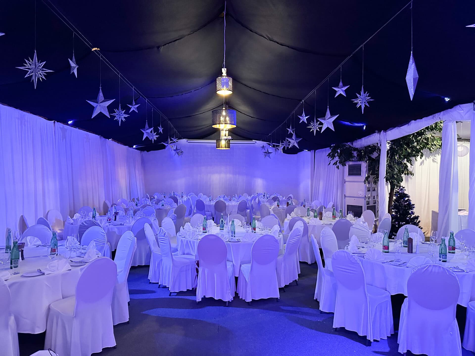 20231124_162116139_iOS Festzelt des Chadim mit eleganten Tischen und Stühlen, dekoriert mit Sternen und stimmungsvollem Licht, ideal für Veranstaltungen bis zu 120 Personen.