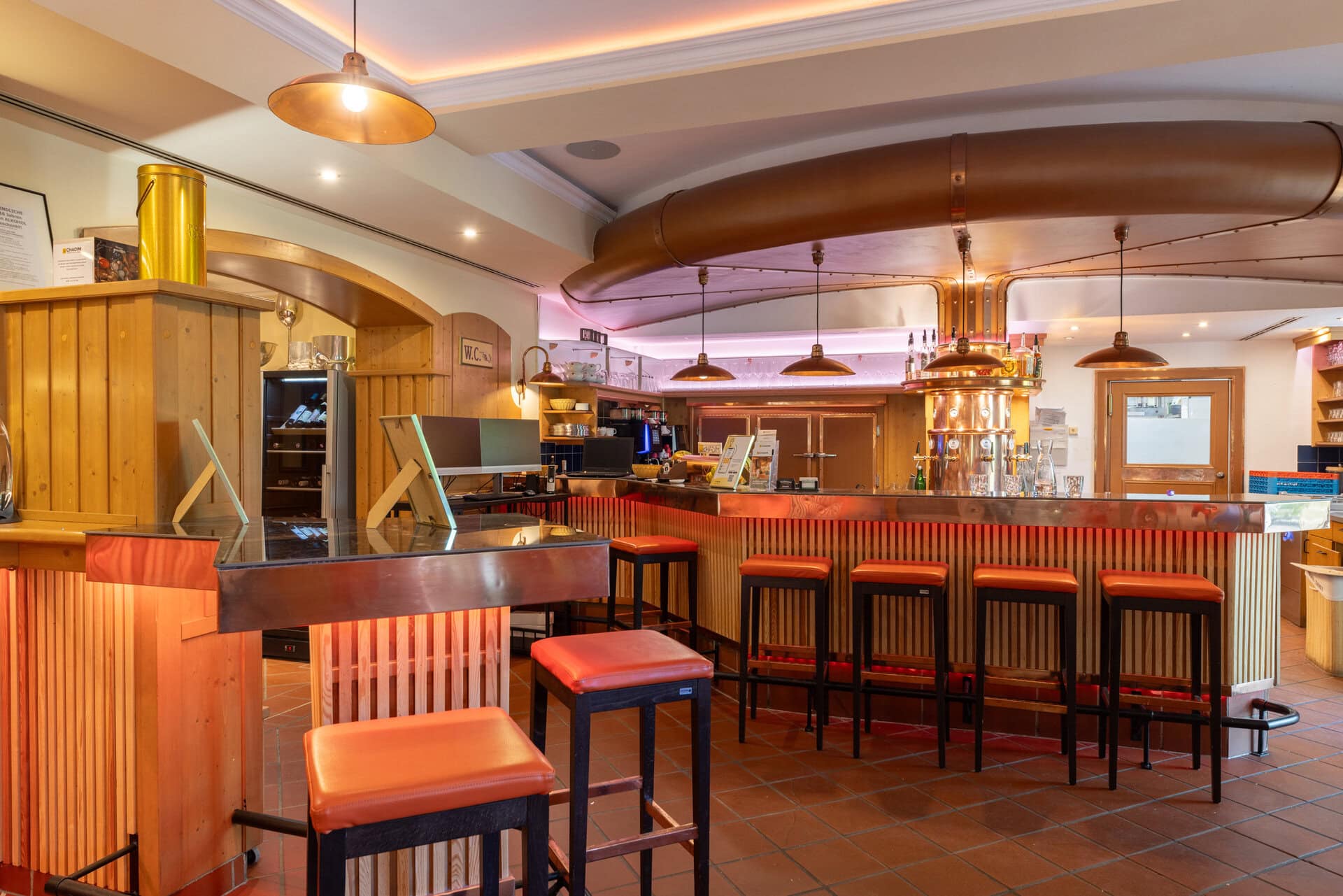 © Adrian Almasan | www.adrianalmasan.com Gemütliche Bar im Lokal Das Chadim mit Holzverkleidung, modernen Hockern und warmem Licht, ideal für gesellige Veranstaltungen und Feste.