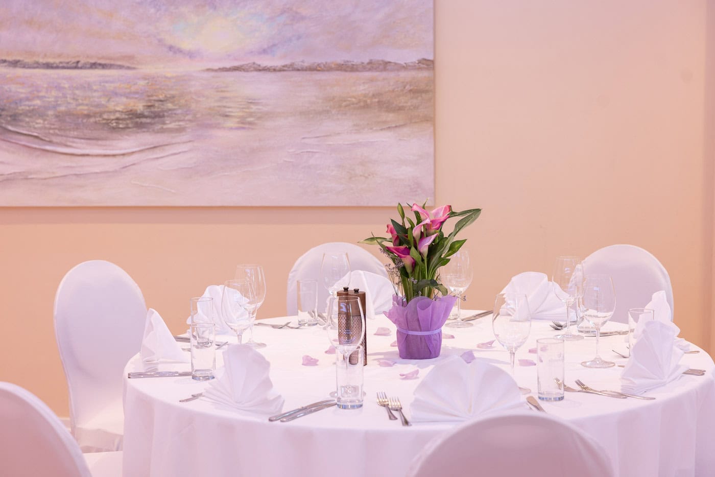 © Adrian Almasan | www.adrianalmasan.com Elegant gedeckter Tisch mit weißen Stoffservietten, Gläsern und einer Blumenmitte, umgeben von einem geschmackvollen Ambiente, ideal für Bankettveranstaltungen im Das Chadim.