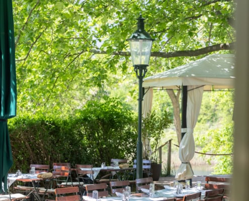 © Adrian Almasan | www.adrianalmasan.com Gastgarten mit schattigen Bäumen, Tischen und Stühlen, Pavillon im Grünen, ideal für Veranstaltungen bei Das Chadim.