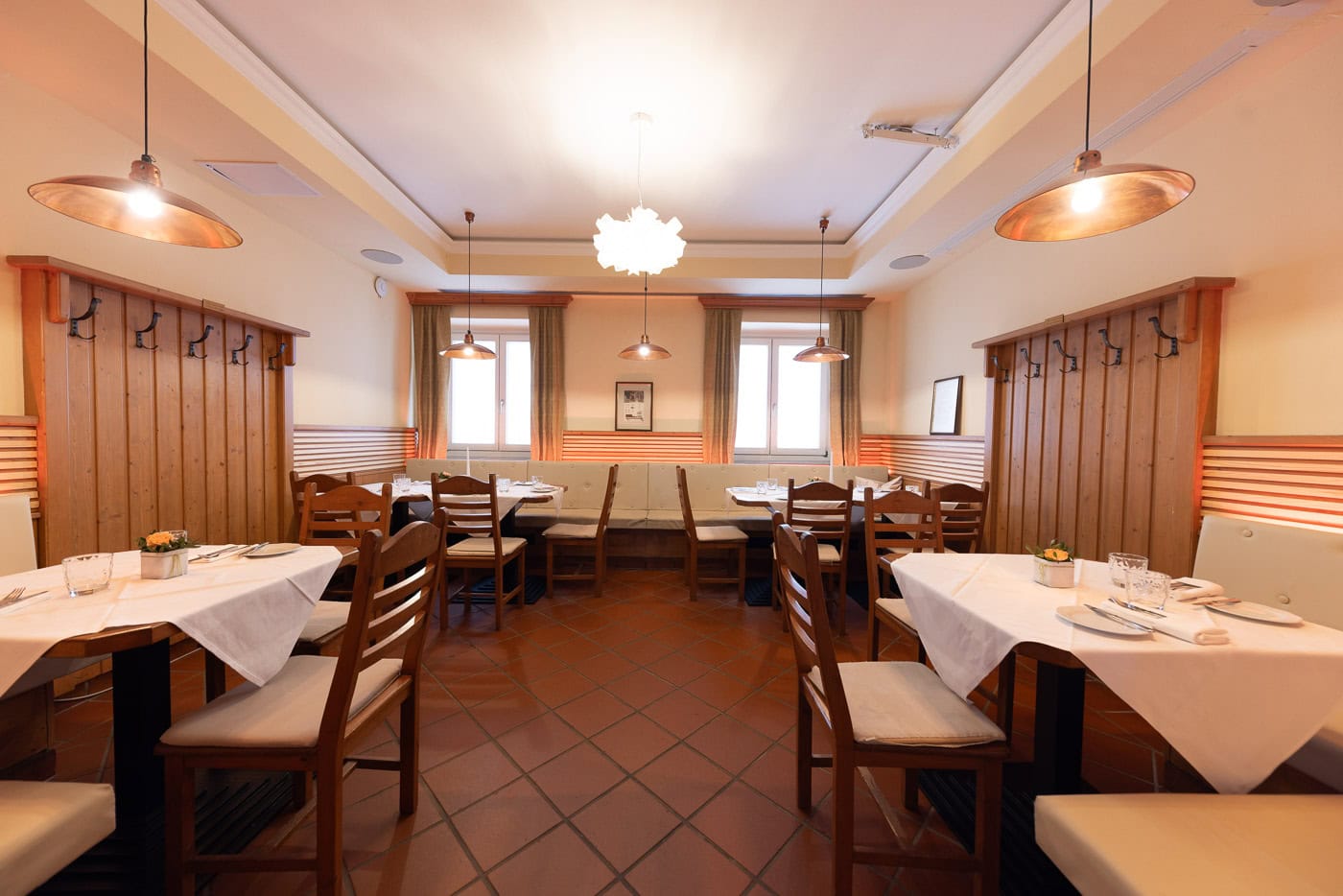 © Adrian Almasan | www.adrianalmasan.com Gemütlicher Restaurantbereich mit Holztischen und Stühlen, warmen Pendelleuchten, Fenster mit Vorhängen, Platz für bis zu 120 Personen, ideal für Veranstaltungen und Feiern bei Das Chadim.