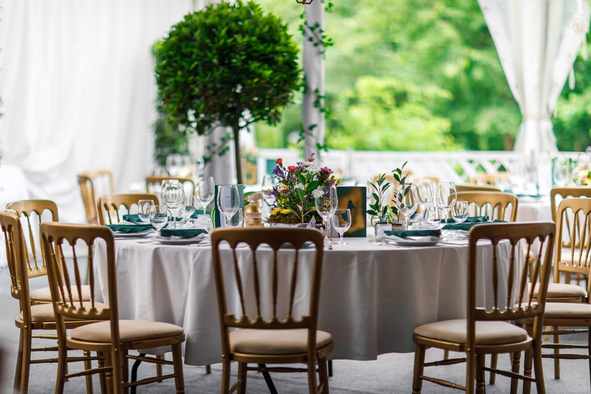 © Adrian Almasan | www.adrianalmasan.com Elegant gedeckter Tisch im Festzelt von Das Chadim, umgeben von Pflanzen und Blick ins Grüne, ideal für Veranstaltungen und Feiern.