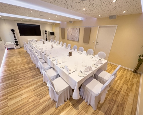 IMG_0758 Hochwertig gestalteter Bankettraum mit langem Tisch, eleganten weißen Stühlen und akustisch optimierten Wänden für unvergessliche Veranstaltungen im Das Chadim.