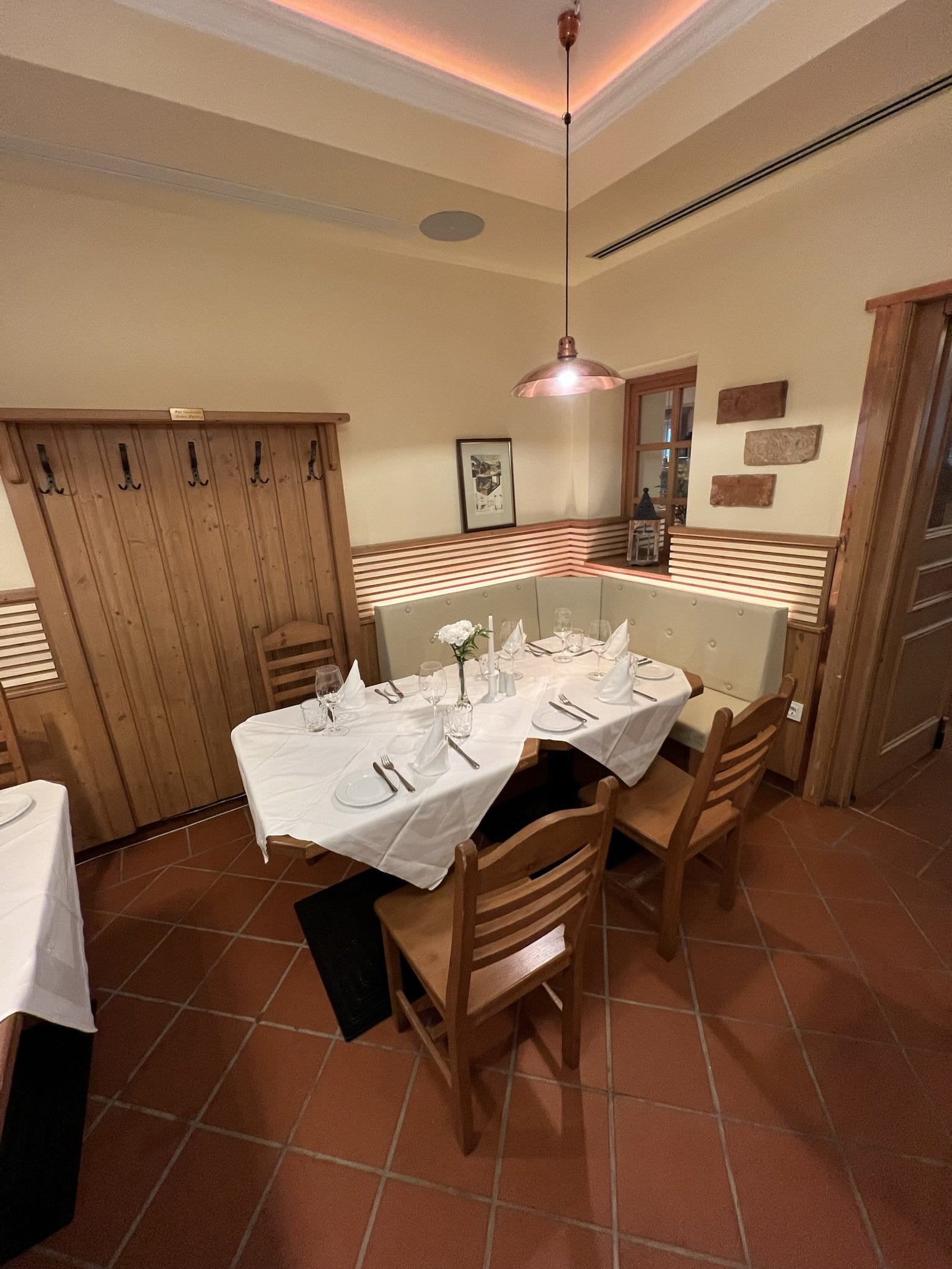 IMG_5539 Gemütlicher Restaurantbereich mit Holzverkleidung, eleganten Tischen und Stühlen, dekoriert mit Blumen und Geschirr, ideal für Familienfeste und kleinere Veranstaltungen im Das Chadim.