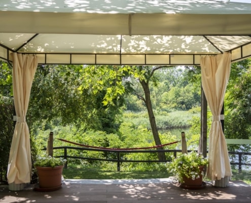 K1600_herbst-6222 Blick auf den Gastgarten von Das Chadim mit schattigen Bäumen, Pflanzen und Aussicht auf den See, ideal für Veranstaltungen und entspannte Momente im Freien.