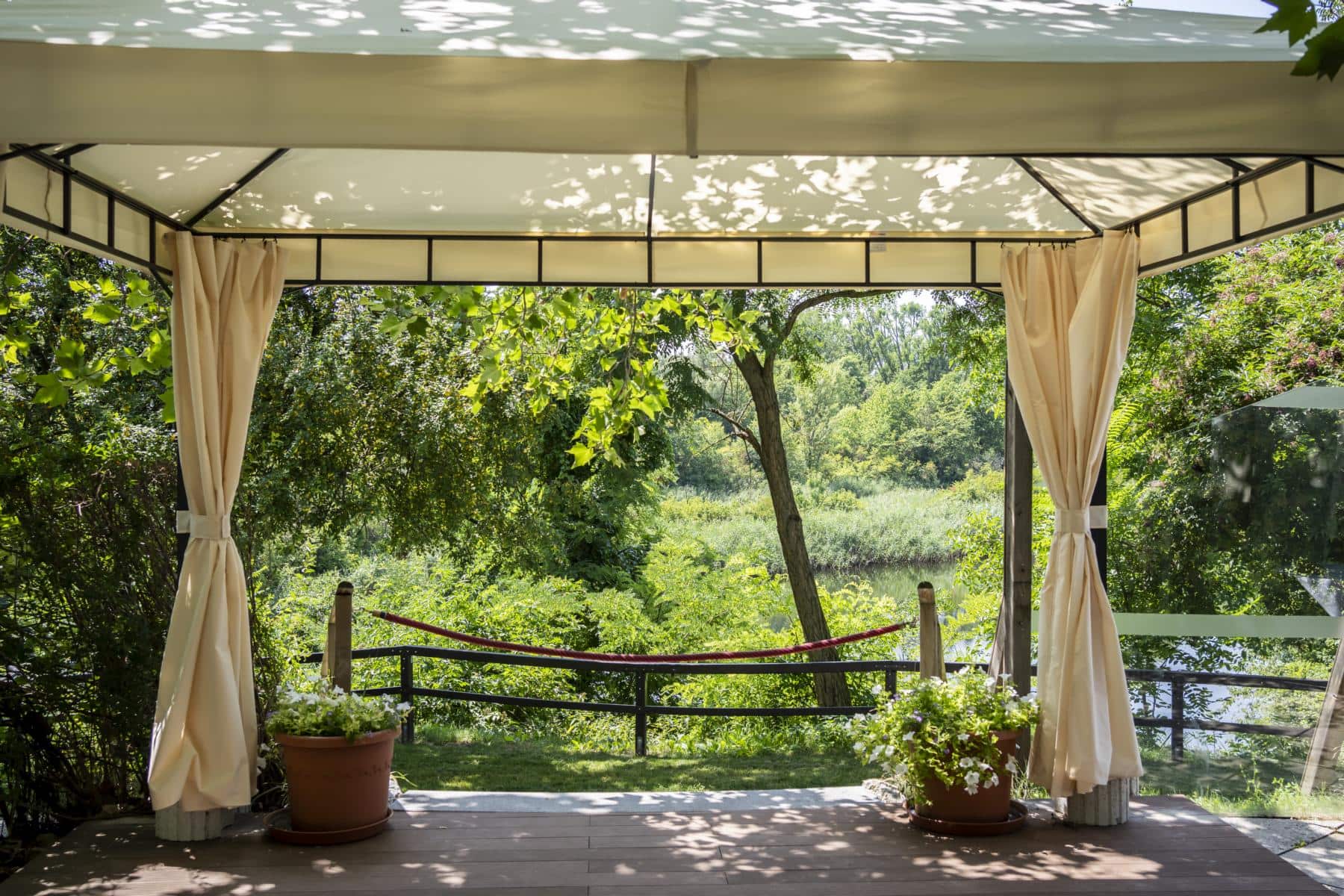 K1600_herbst-6222 Terrasse mit Blick auf den Garten und den angrenzenden See, umgeben von Bäumen und Pflanzen, ideal für Veranstaltungen im Freien bei Das Chadim.